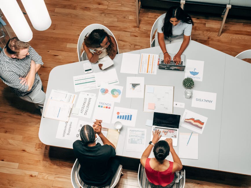 A diverse group working on marketing strategies with charts and laptops in an office setting